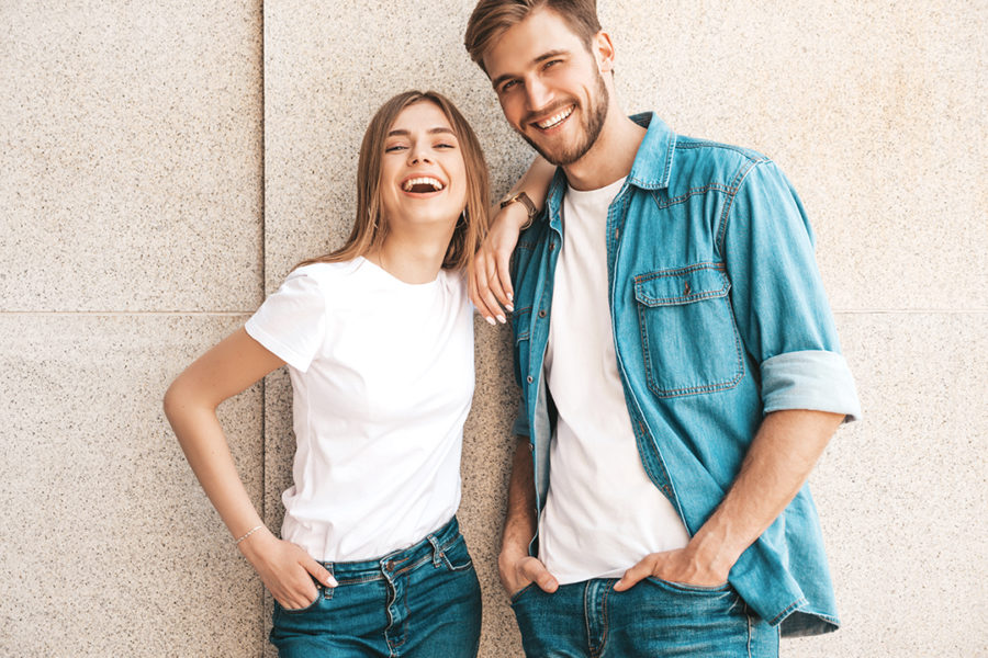 Portrait of smiling beautiful girl and her handsome boyfriend wearing denim and basic Tshirts